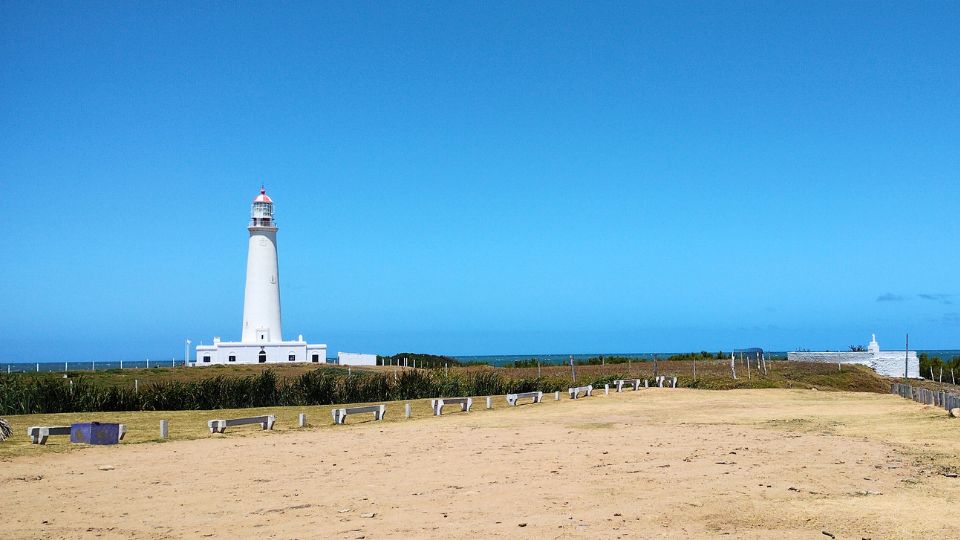 O farol branco contrasta com o céu azul da Praia de Paloma