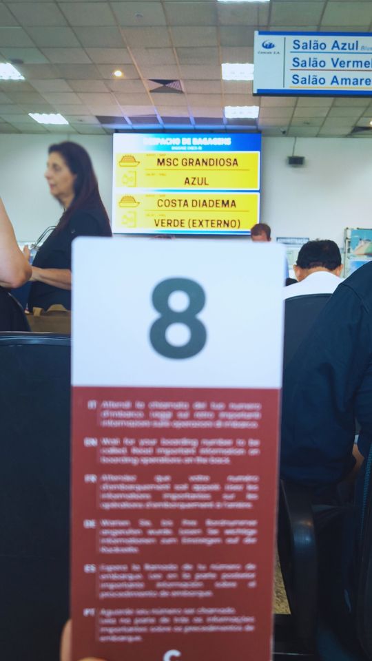 Painel de chamada para embarque no cruzeiro e cartão do grupo de embarque.