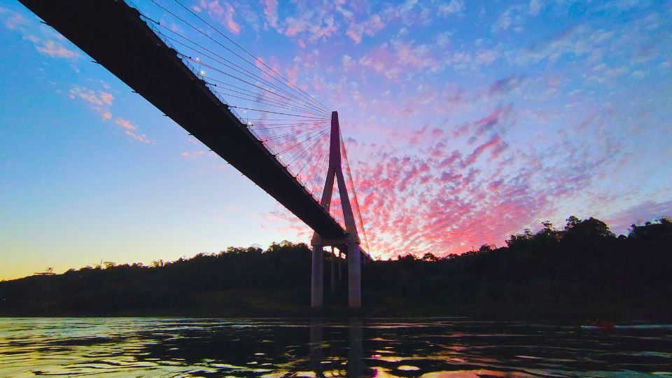Retornando ao porto o Kattamaram II passa novamente sob a Ponte da Integração, tons vermelhos dos últimos raios de sol se espalham no céu