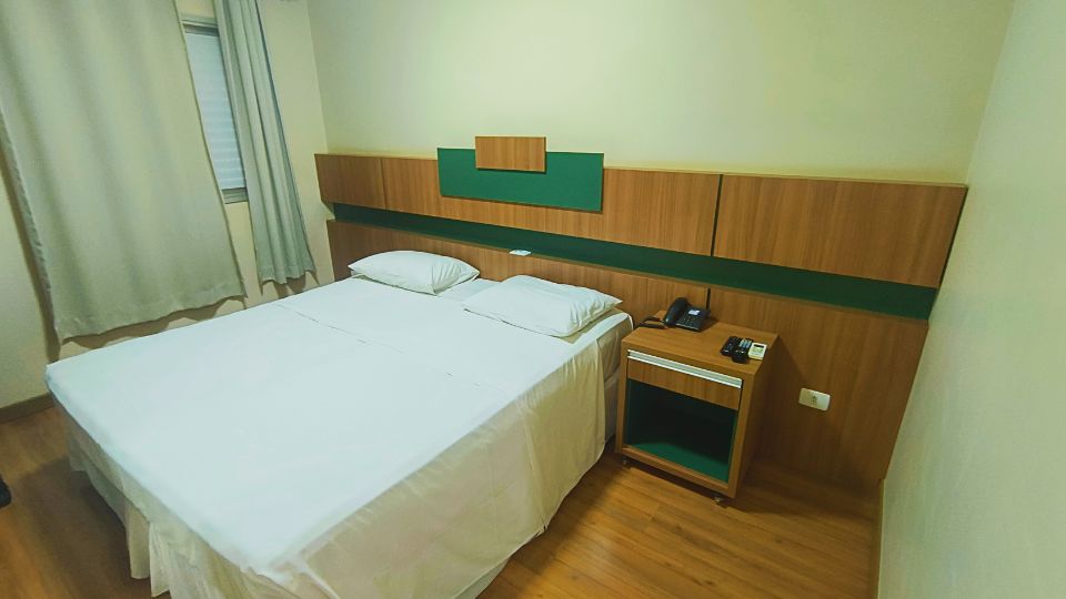 Quarto do Hotel Aero Park, com cama de casal, frigobar, televisão e outras comodidades