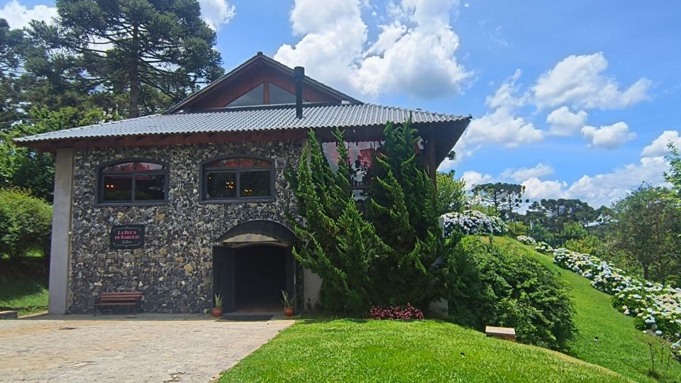 Fachado do prédio do Restaurante Buca de Barolo em pedras e a bonita paisagem ao redor