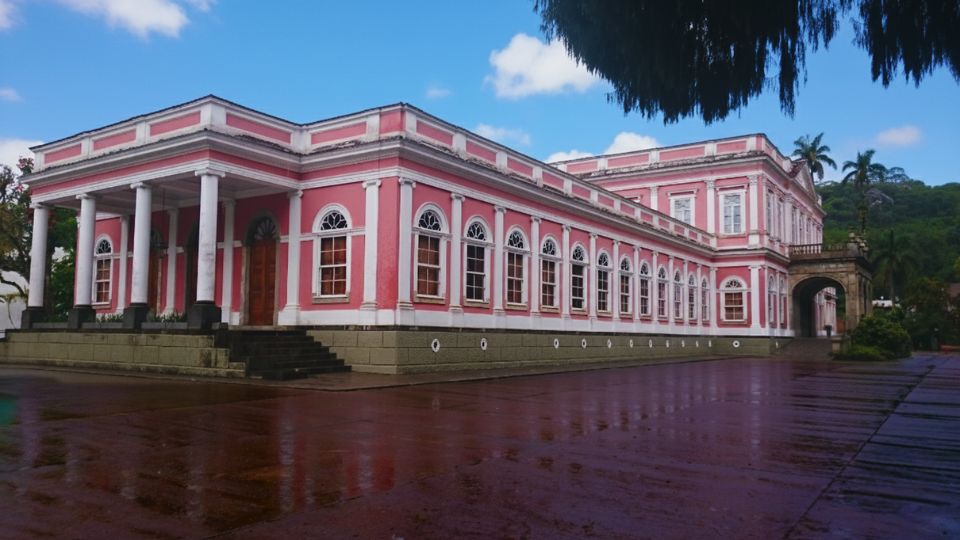 O museu imperial de Petrópolis é um prédio grande, rosa e retangular. tem janelas brancas dispostas simetricamente ao longo da fachadas 